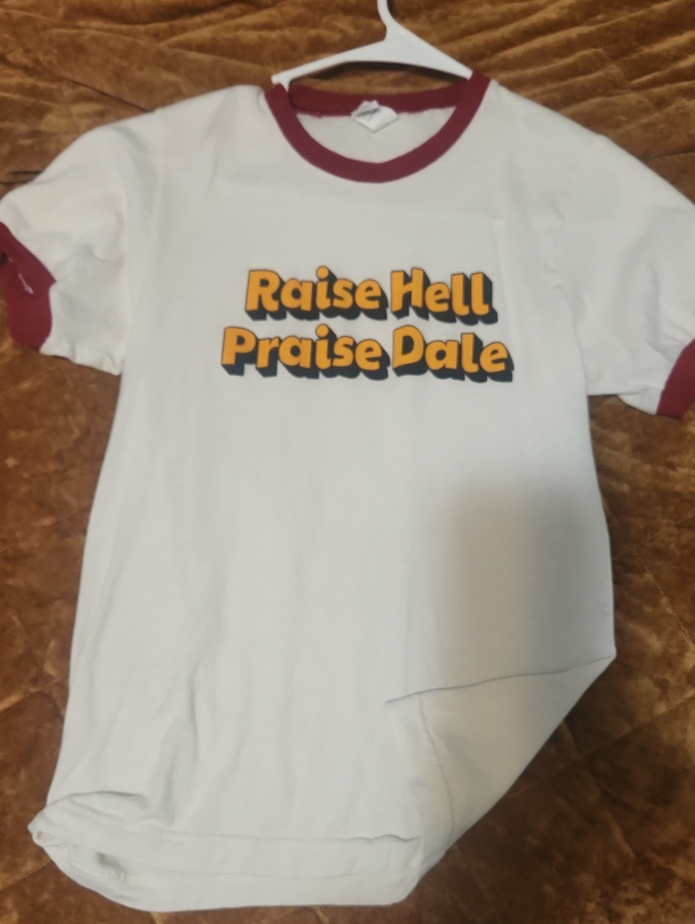 White Ringer Tee with Maroon Trim and 'Raise Hell Praise Dale' Graphic